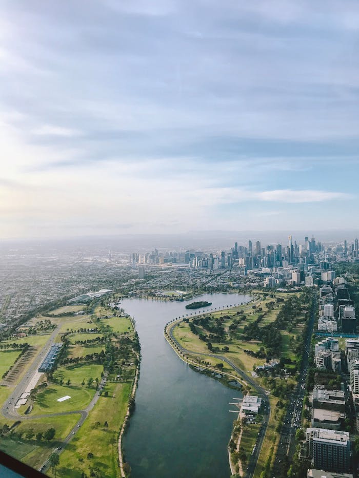 Breathtaking aerial view of Melbourne skyline along the Yarra River with lush greenery.